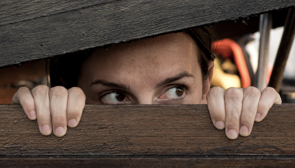 hiding man behind wood after downloading videos 