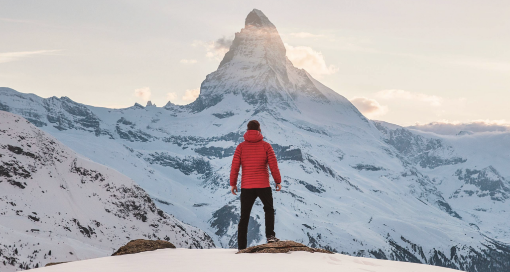 man looking at mountain in the snow 