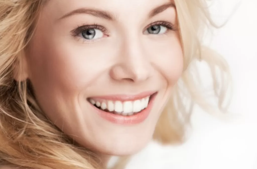 smiling blonde lady with green eyes